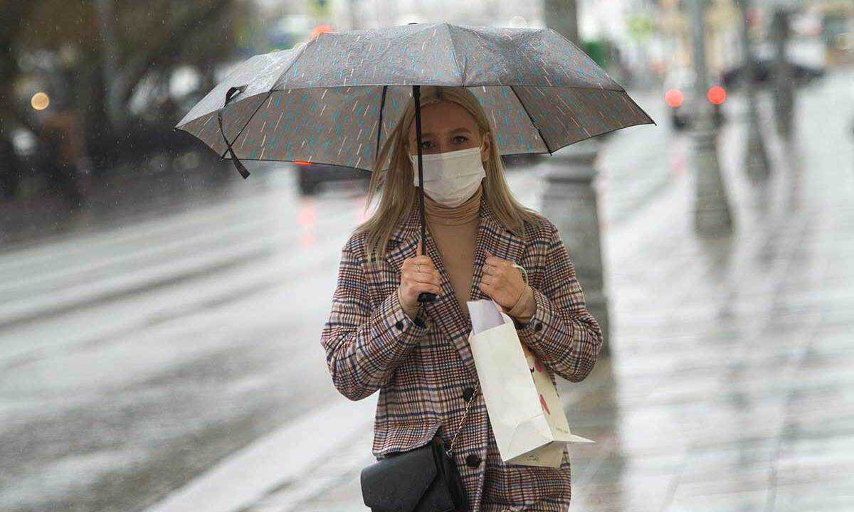 Екатеринбург. Девушка в медицинской маске по зонтом во время режима самоизоляции введенного для нераспространения коронавирусной инфекции COVID-19